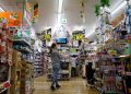 Japan says overall economy recovering, cuts view on corporate profits