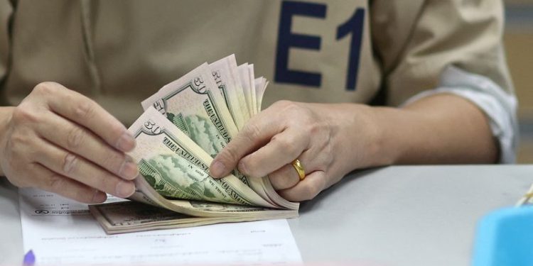 Dollar holds near two-year high; yuan under threat